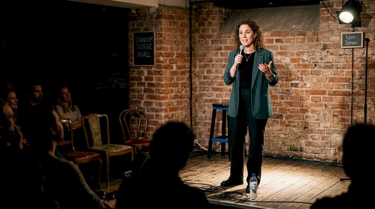 1773972129337_Swedish-standup-comedian-performing-on-small-stage