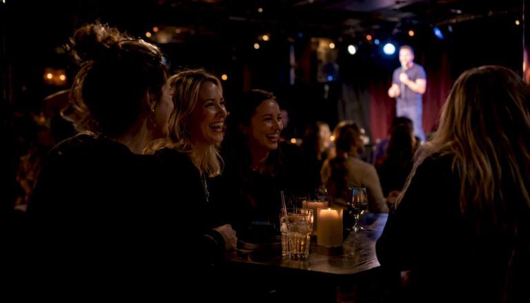Kvinnor skrattar tillsammans under en live standupshow