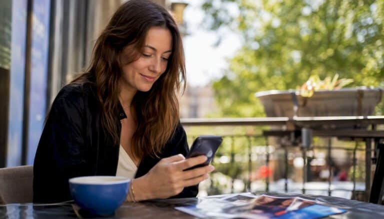Kvinna bläddrar bland komediföreställningar i mobilen